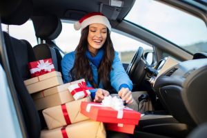 Featured image showing a woman in her car with multiple Christmas gifts in her front seat. Shopping locally.